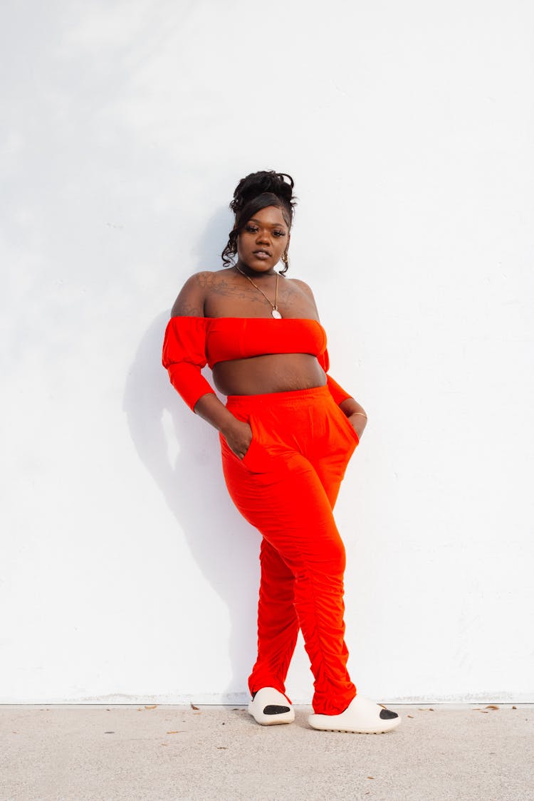 Woman Wearing Red Outfit On White Wall