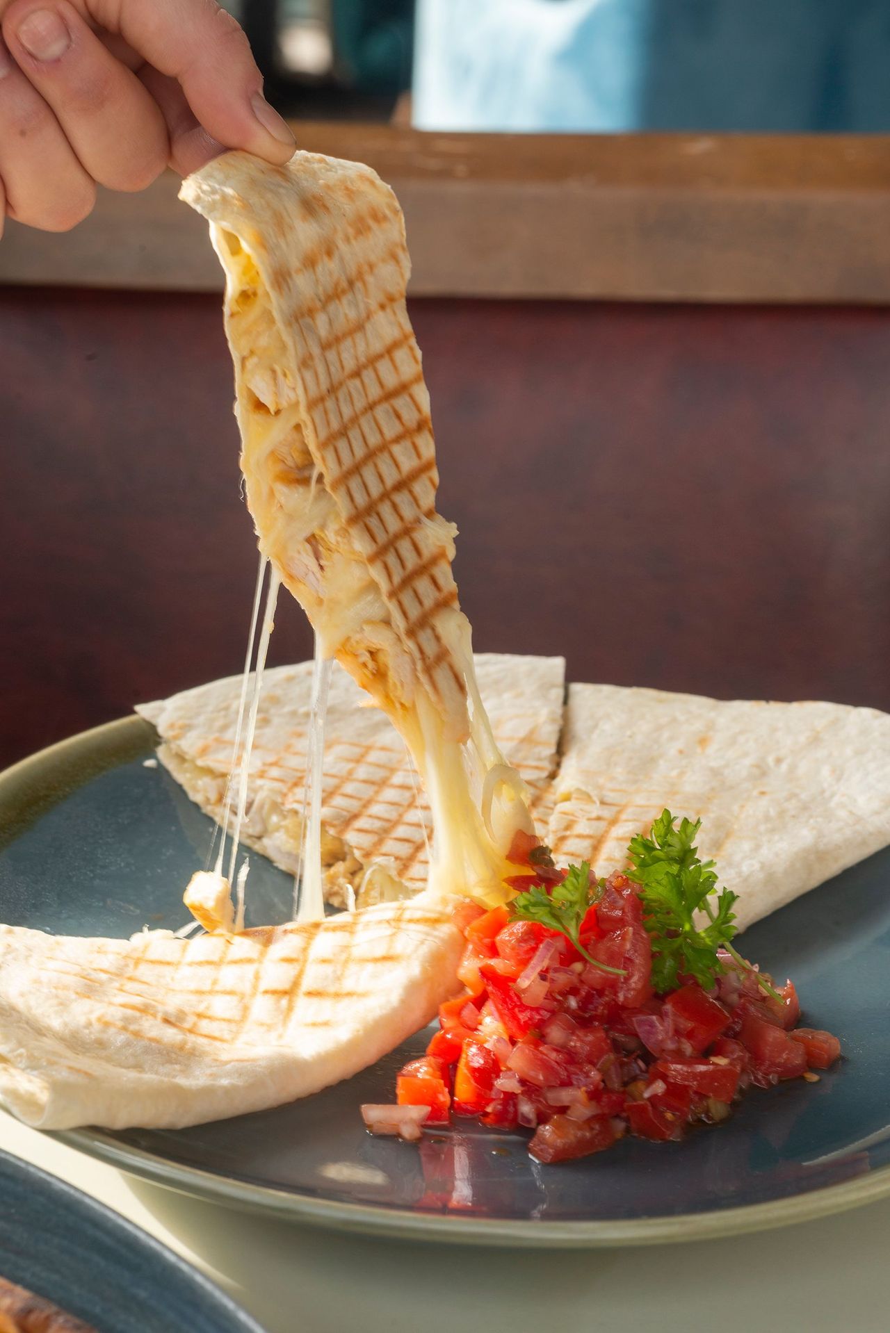 Cheese quesadilla with a melted cheese pull, served with fresh tomato salsa
