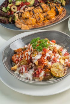 Loaded fries with toppings, garnished with lime and parsley, perfect for food photography.