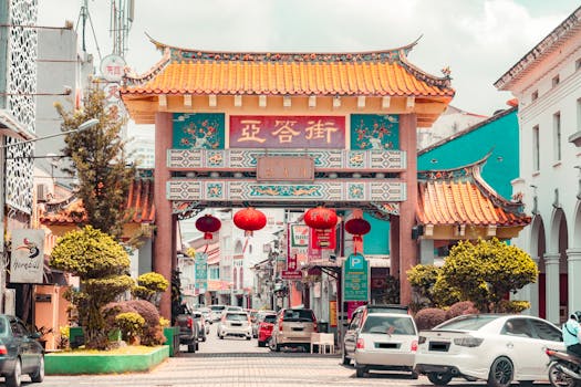 Bustling street scene featuring a traditional Chinese archway in a vibrant Asian city.