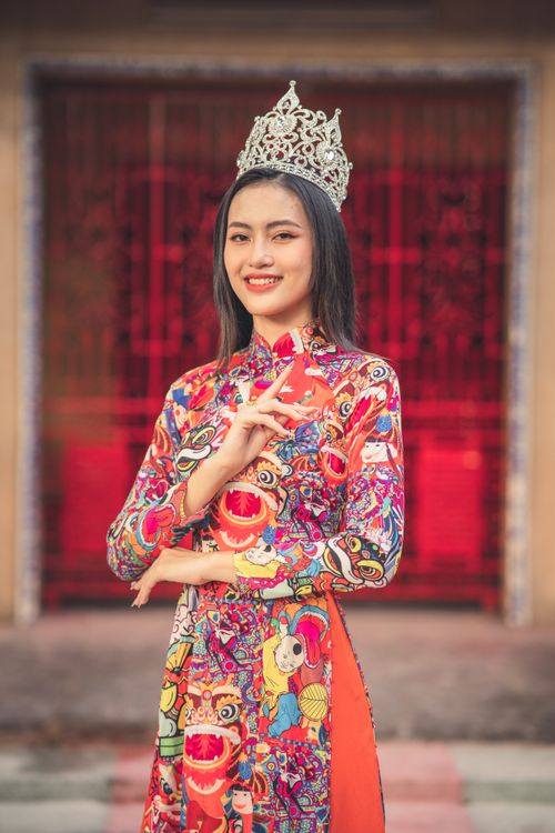Free A woman in colorful traditional attire and a crown, standing proudly and smiling. Stock Photo