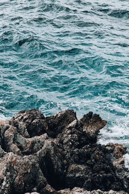 Foto profissional grátis de acenando, formação rochosa, mar