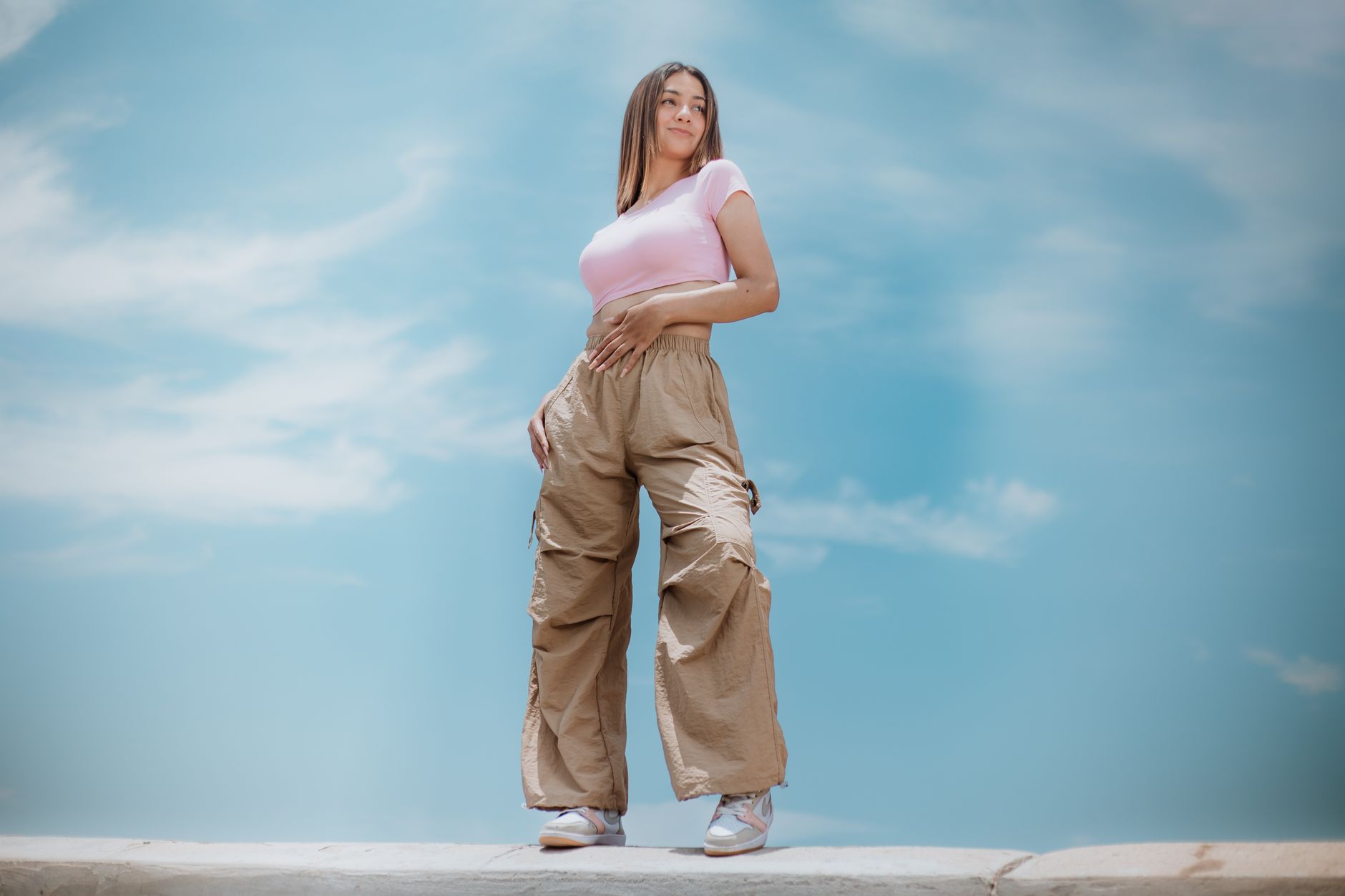 Femme en tenue streetwear complète avec cargo mode et sneakers, incarnant le style ATNT Paris urbain