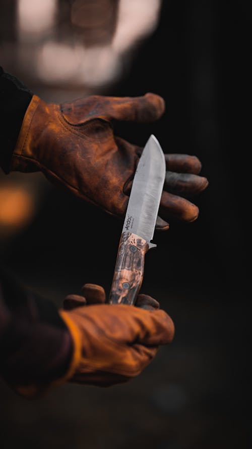 Close-up of Man in Leather Gloves Holding a Sharp Knife 