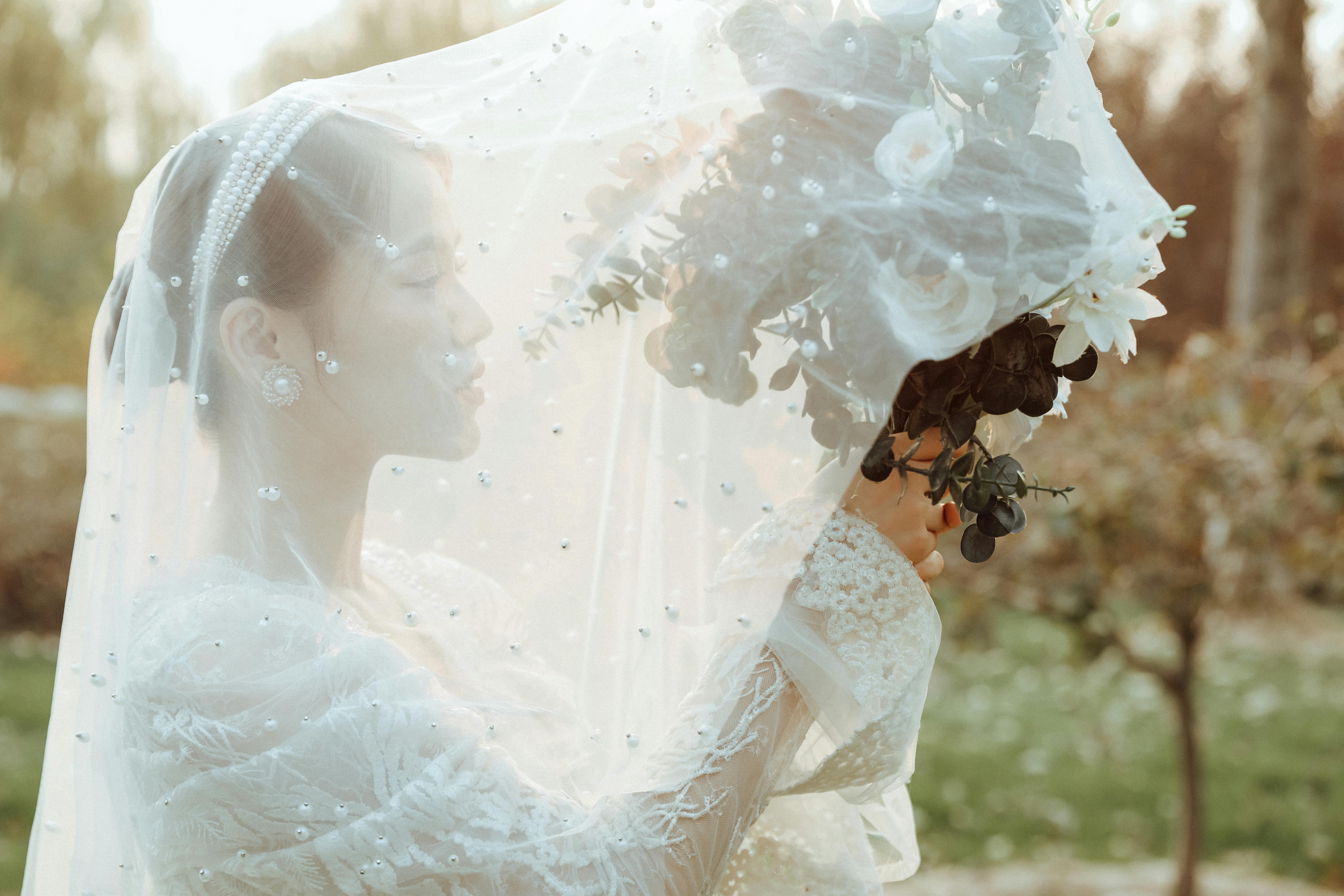 ヴェールをつけた真珠のヘッドドレスを着用した自由な花嫁のストックフォト