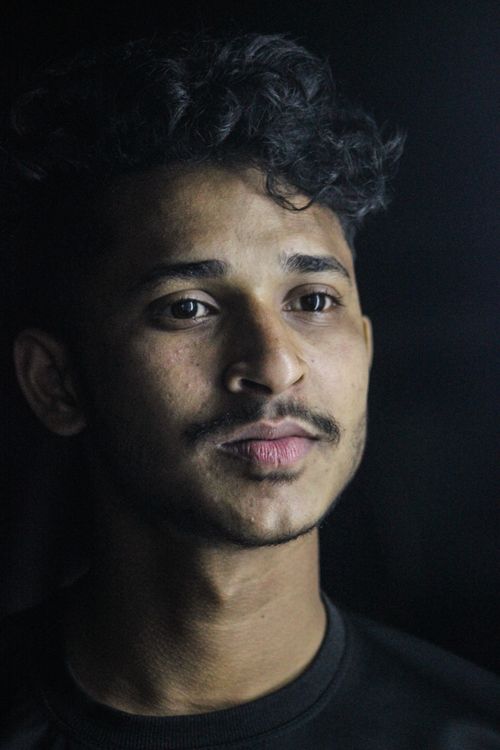 Free Studio portrait of a young man with dark curly hair and mustache, captured with soft lighting. Stock Photo