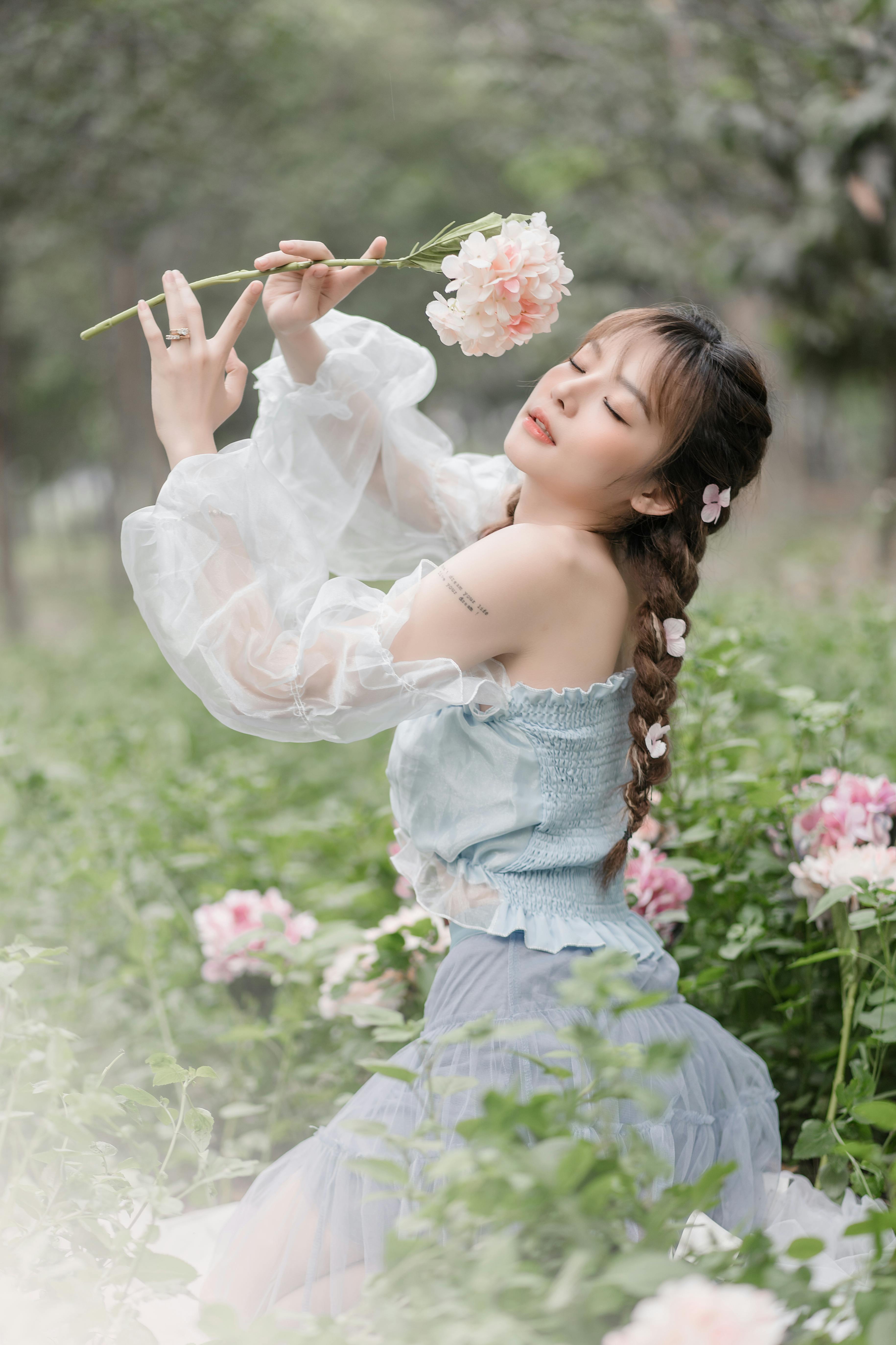 Portrait of a woman in a floral garden, dressed fashionably with delicate flowers.