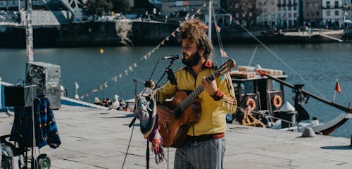 Musician Playing Guitar in a Harbor 