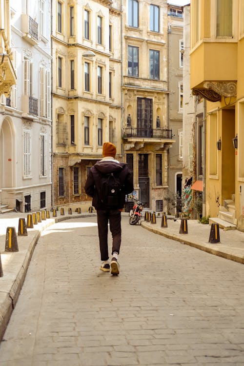 Back View of a Man Walking on the Street 