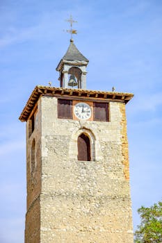 A stunning view of the historic clock tower in Peñafiel, Spain under a clear blue sky.