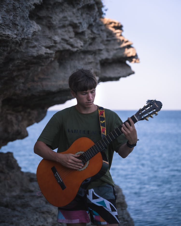 Man Playing Guitar By Sea