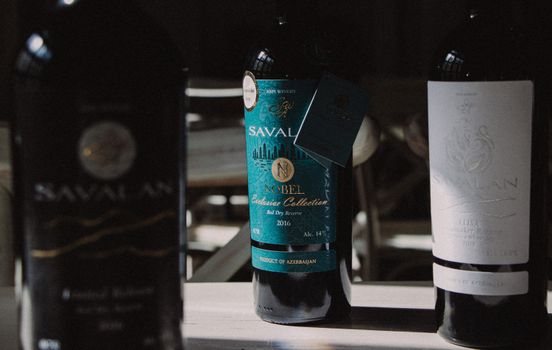 Three Savalan wine bottles arranged on a table, showcasing labels and brand.