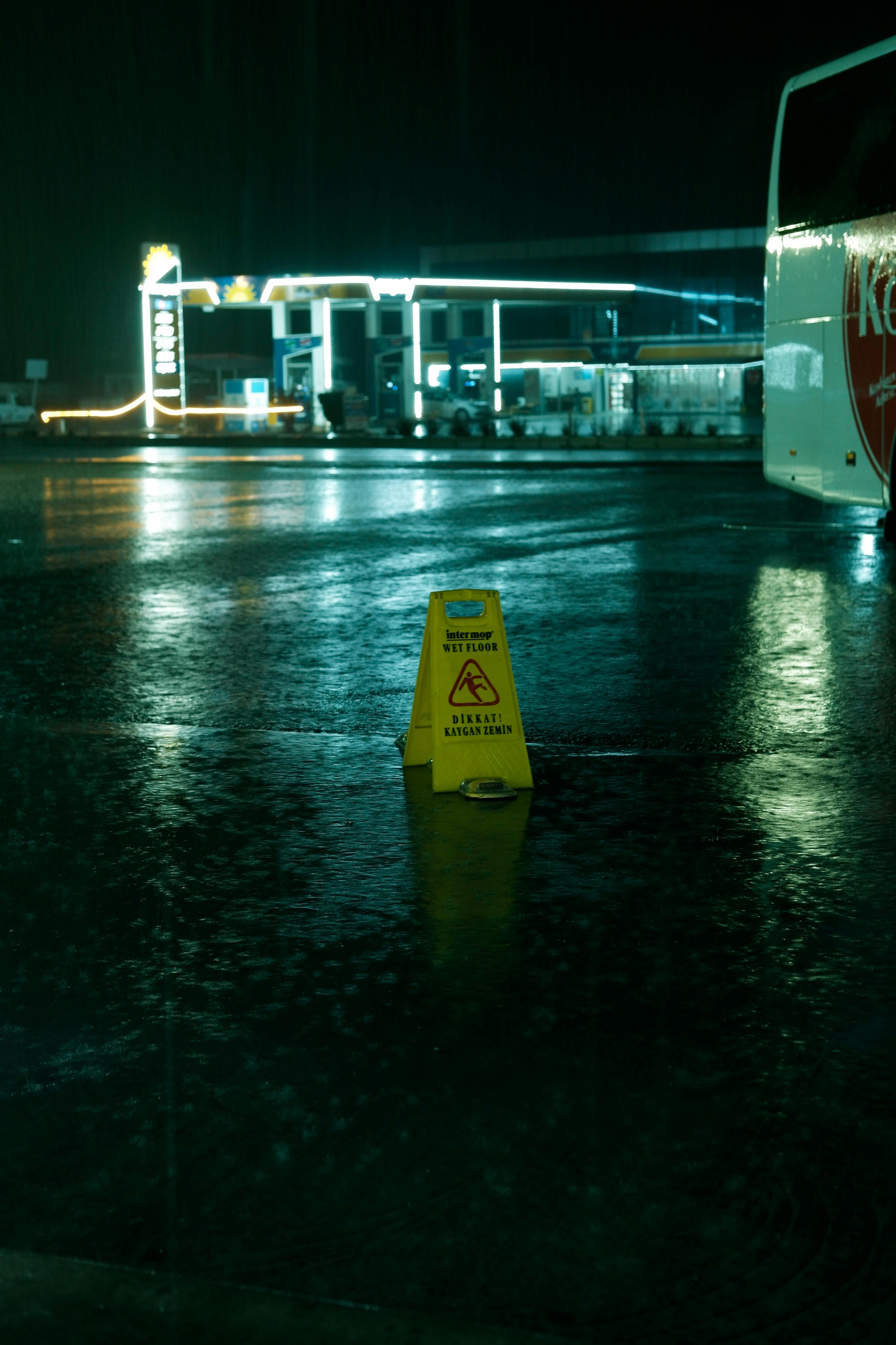 A Warning about a Slippery Surface and an Illuminated Gas Station in
