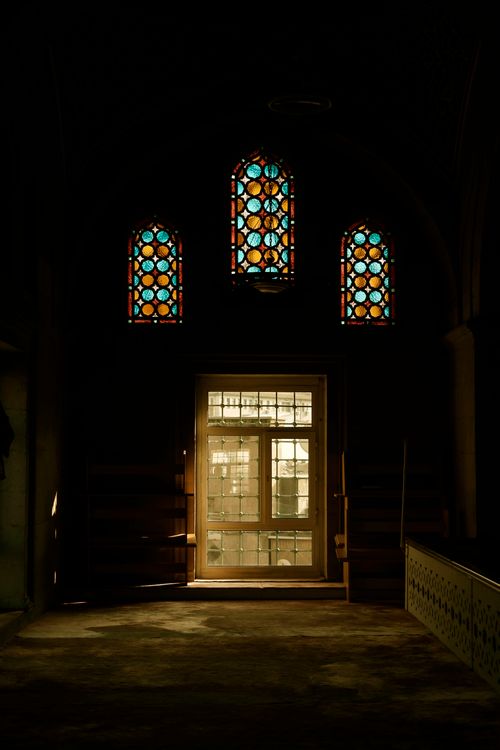 Free Captivating church interior with colorful stained glass windows casting light and shadows. Stock Photo