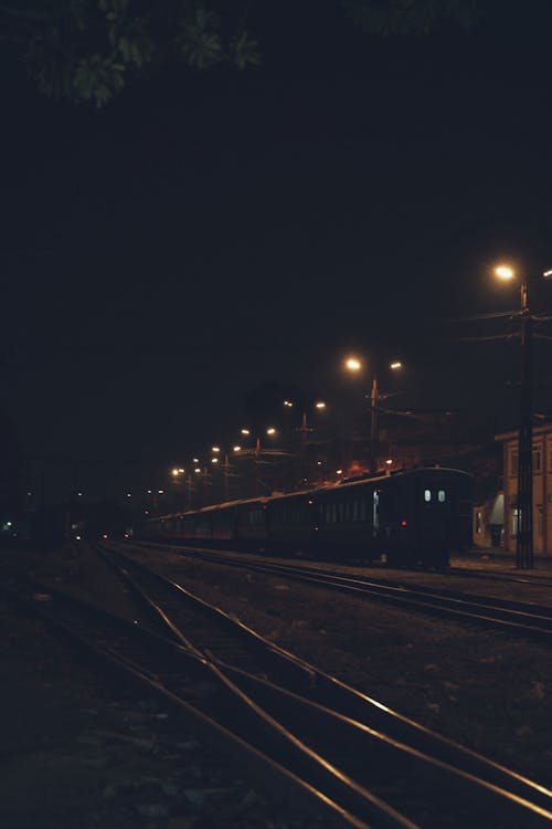 Бесплатное стоковое фото с вертикальный выстрел, железнодорожная станция, ночь
