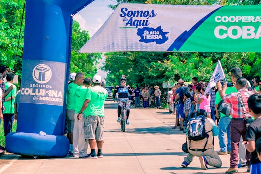 在一场户外比赛中，一名自行车骑手在人群的欢呼声中冲过了终点线