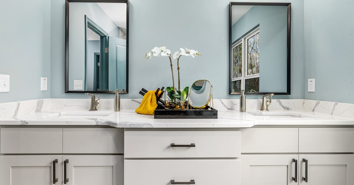 A large round mirror with a golden sunburst design mounted on a pink wall.