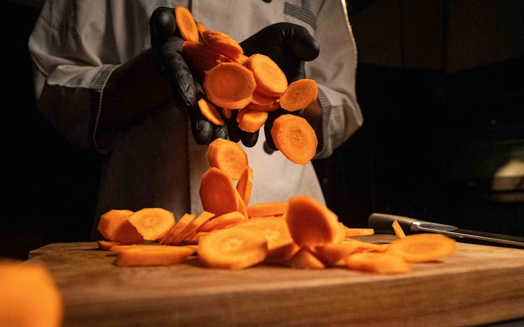 Close-up Of A Chef Holding A Chopped Carrot 