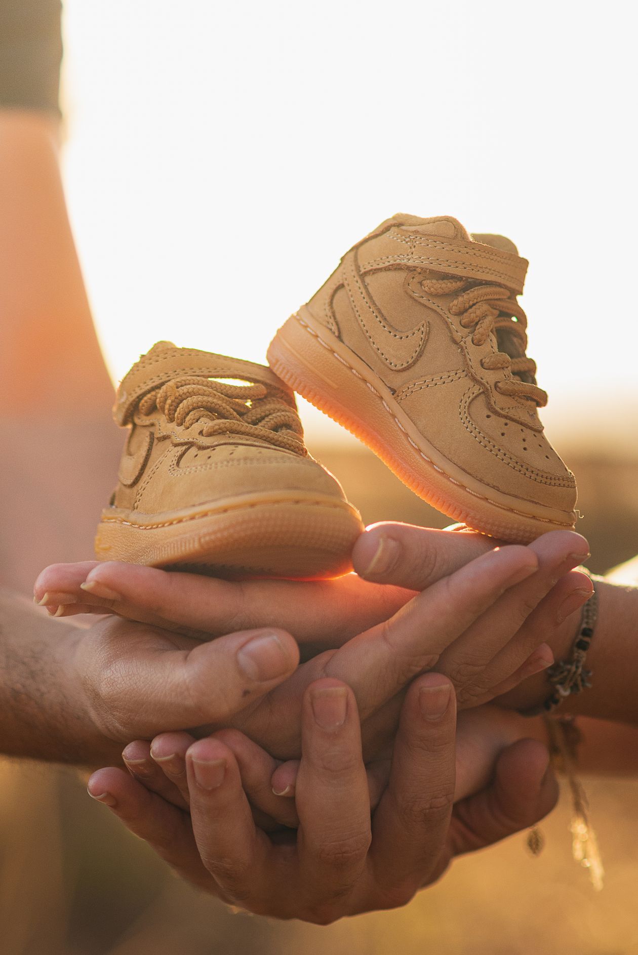 Manos sosteniendo zapatos de bebé