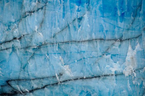 Free Detailed view of blue ice texture with cracks and layers, showcasing glacial patterns and colors. Stock Photo