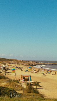 A vibrant summer beach scene in Punta del Diablo, Uruguay, capturing lively seaside activities.