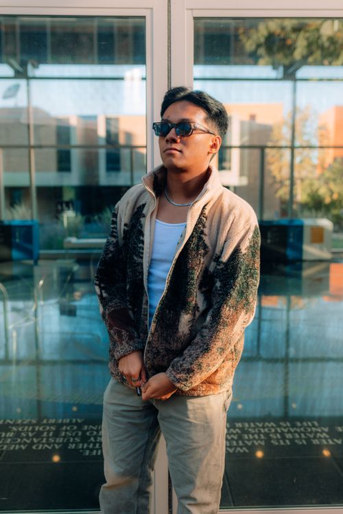 Free Stylish young man posing confidently in urban setting with sunglasses and casual outfit. Stock Photo