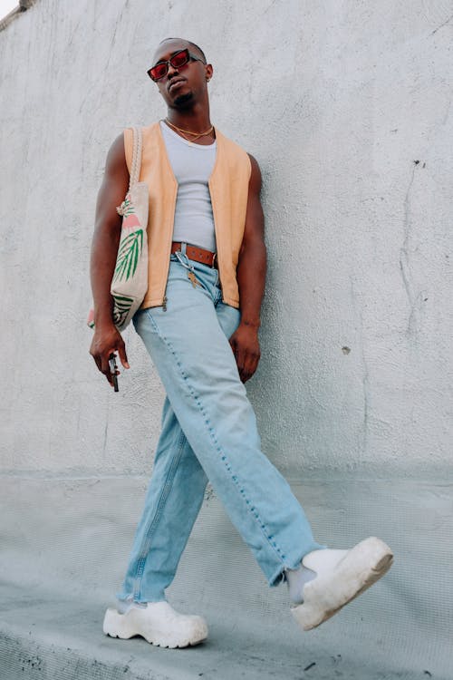 Man in Cardigan and White Tank Top Posing by Gray Wall