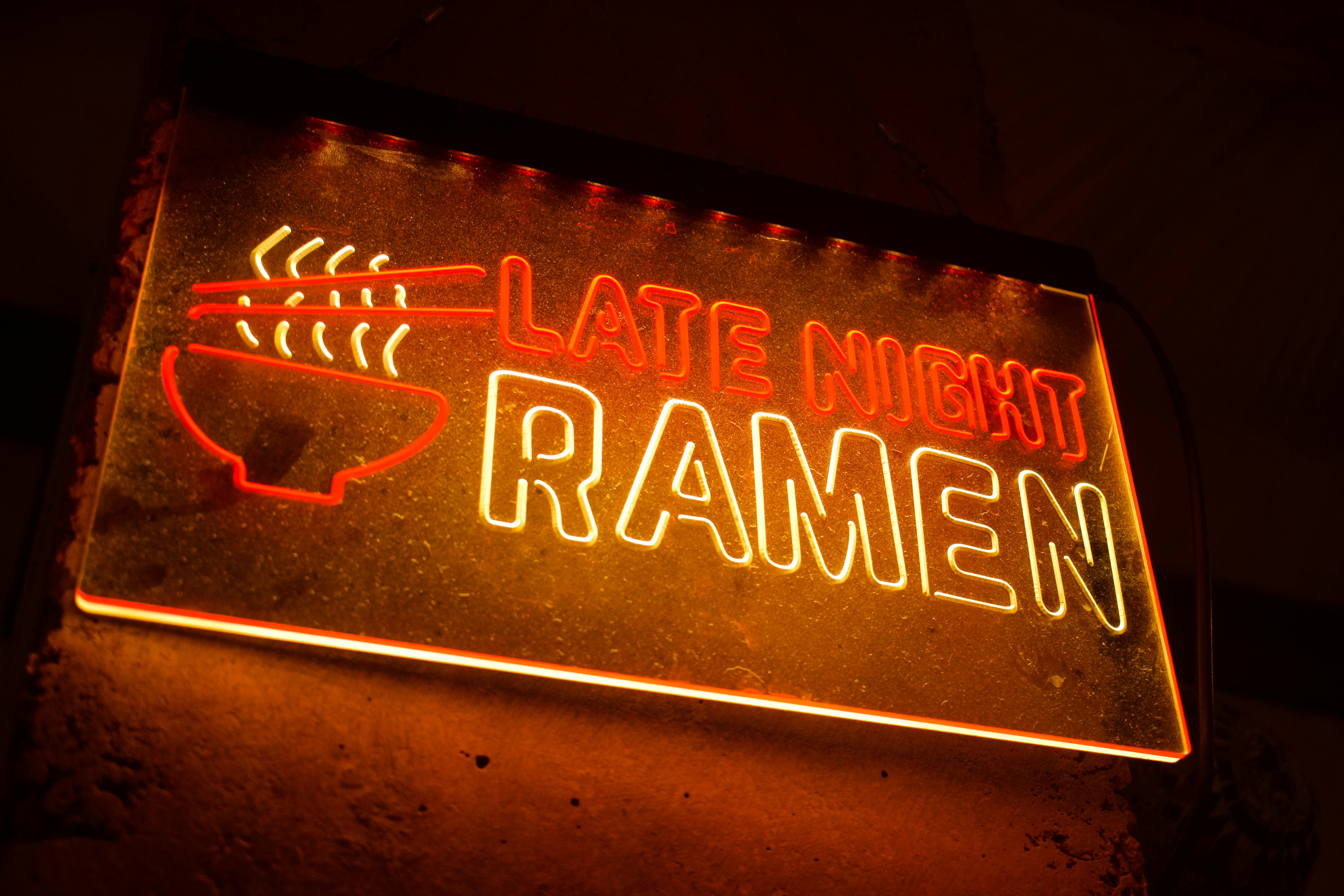 Vibrant neon sign featuring ''Late Night Ramen'' in bright colors, perfect for nightlife themes.
