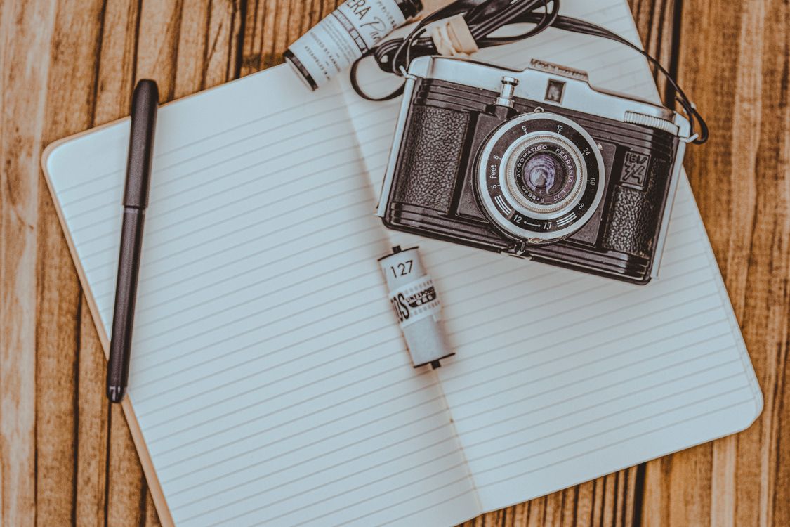 Camera Notepad Retro Camera on Empty Notepad on Wooden Table · Free Stock Photo