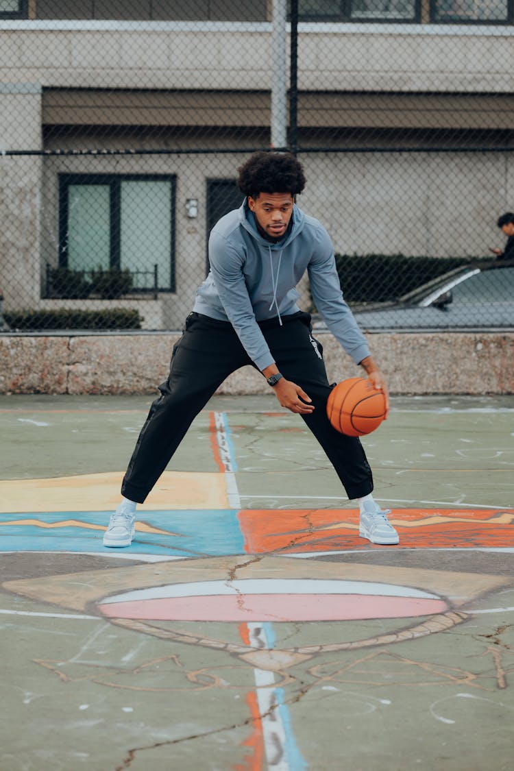 Young Man Playing Basketball On Court