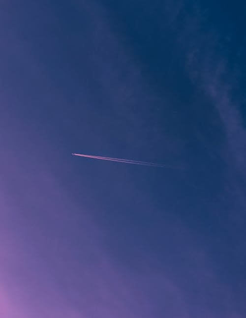 An Airplane Flying High against a Blue Sky