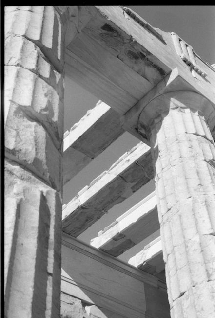 Dramatic black and white image of ancient stone columns with classic architectural detail.