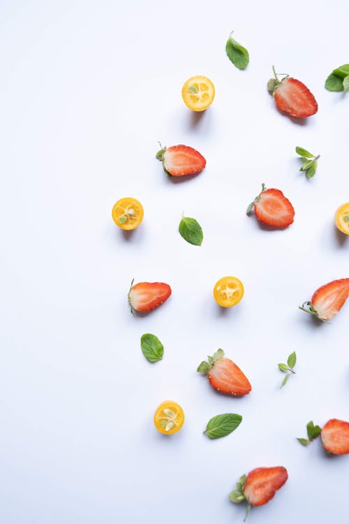 Fruits Sliced in Halves and Mint Leaves on Blue Background