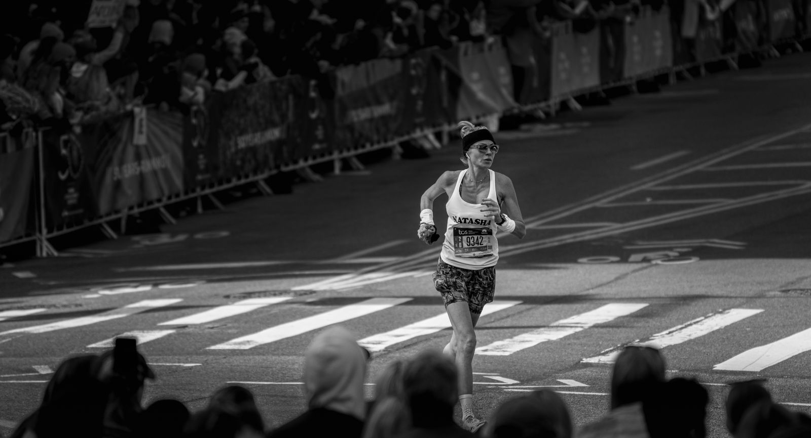 Runner in the New York City Marathon passing a cheering crowd on a city street