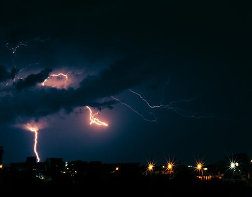 View of Lightning on the Sky above a City at Night 