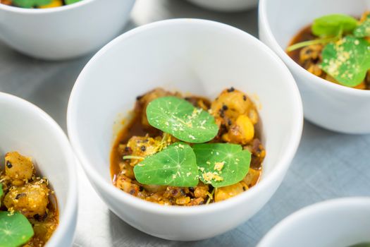 A high-angle view of gourmet potato dish garnished with nasturtium leaves in bowls, perfect for culinary presentations.