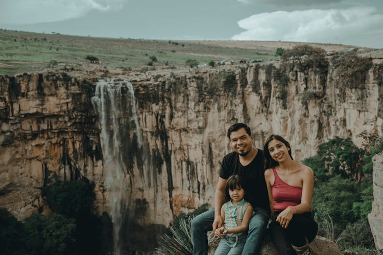 Family Sitting On Rock