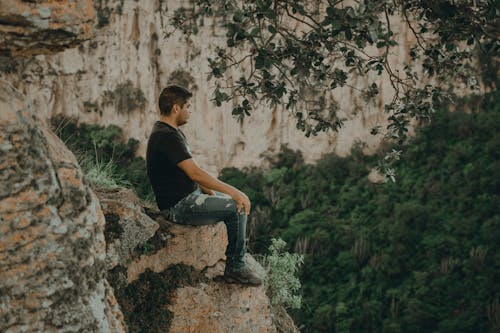 Man Sitting on the Edge of a Cliff 