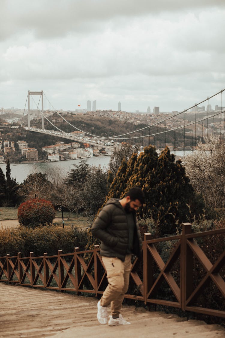 Man Walking Upstairs Near Suspension Bridge