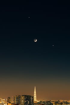 Aerial view of Saint Petersburg's skyline with a crescent moon in the night sky.