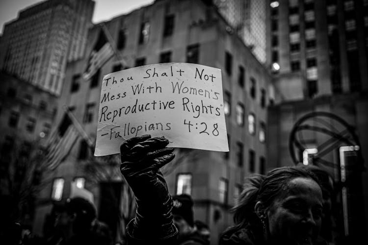 Hand In Glove Holding Banner In Black And White