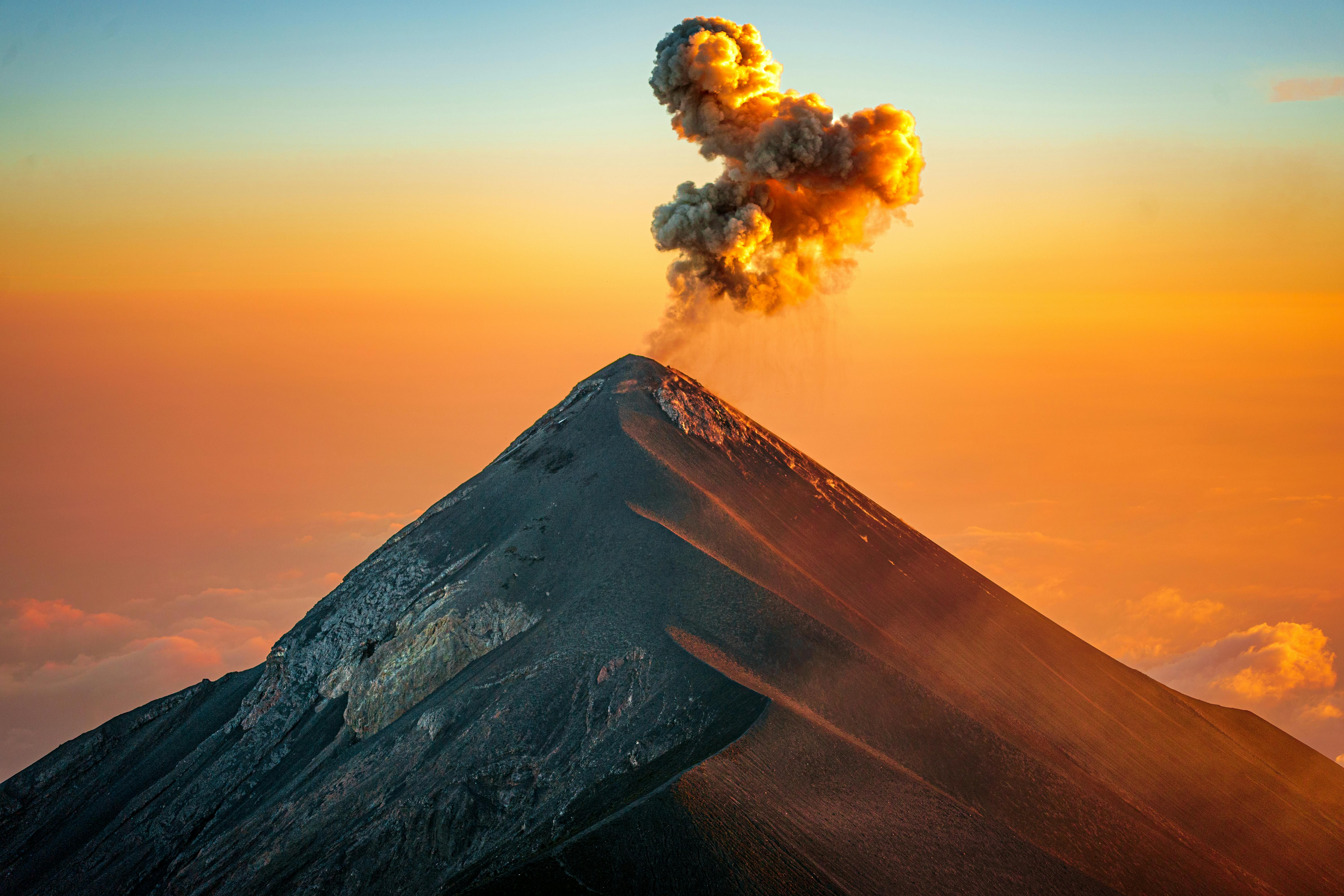 Stunning view of Acatenango Volcano with an erupting plume at sunset, Guatemala.