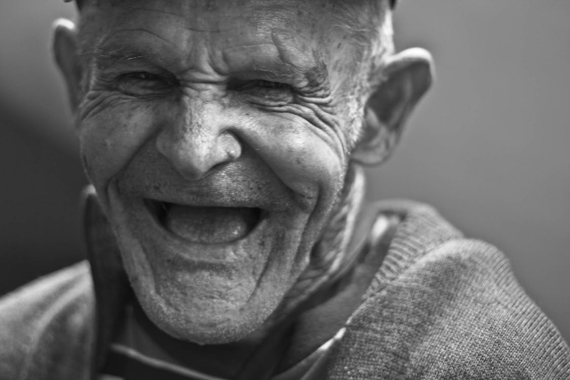 Grayscale Photo of Laughing Old Man