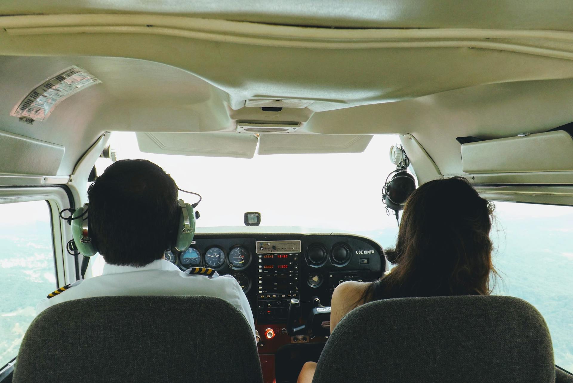 Two pilots in a cockpit navigating through the skies over Blumenau, Brazil, providing a unique aviation perspective.