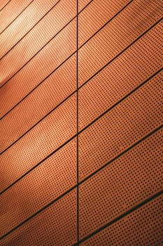 Abstract view of a modern metal wall with geometric patterns and warm lighting.