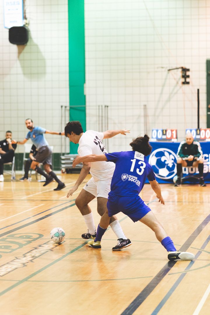 Jogadores de futsal em ação num pavilhão