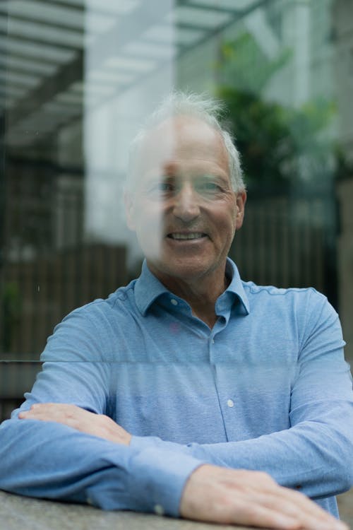 Smiling Man in Shirt behind Window 