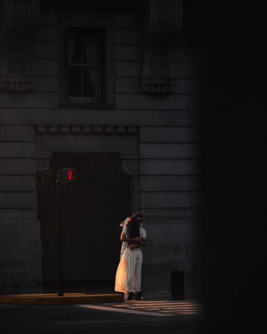 A couple embraces on a dimly lit urban street, creating a romantic atmosphere.