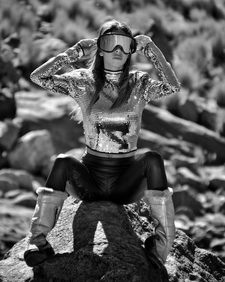 Woman In Goggles Sitting On Rock In Black And White