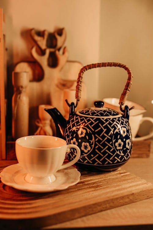 Close-up of a Cup of Tea on a Saucer Next to a Teapot